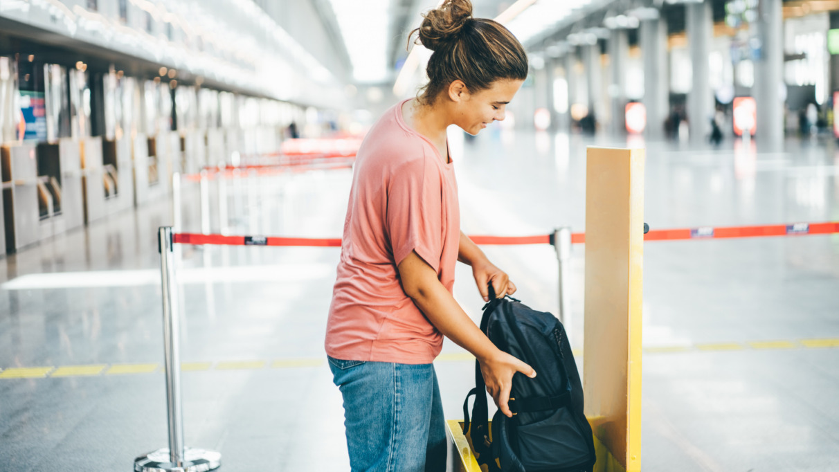 Vrouw meet op luchthaven of haar rugzak niet te groot is voor handbagage