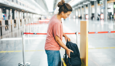 Vrouw meet op luchthaven of haar rugzak niet te groot is voor handbagage