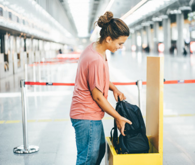 Vrouw meet op luchthaven of haar rugzak niet te groot is voor handbagage