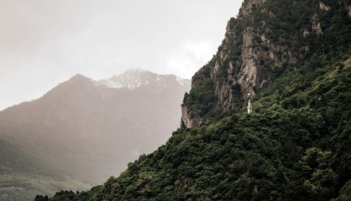 Kleine Mariakapel op een beboste berghelling in Valchiavenna, omringd door steile rotswanden en Alpentoppen