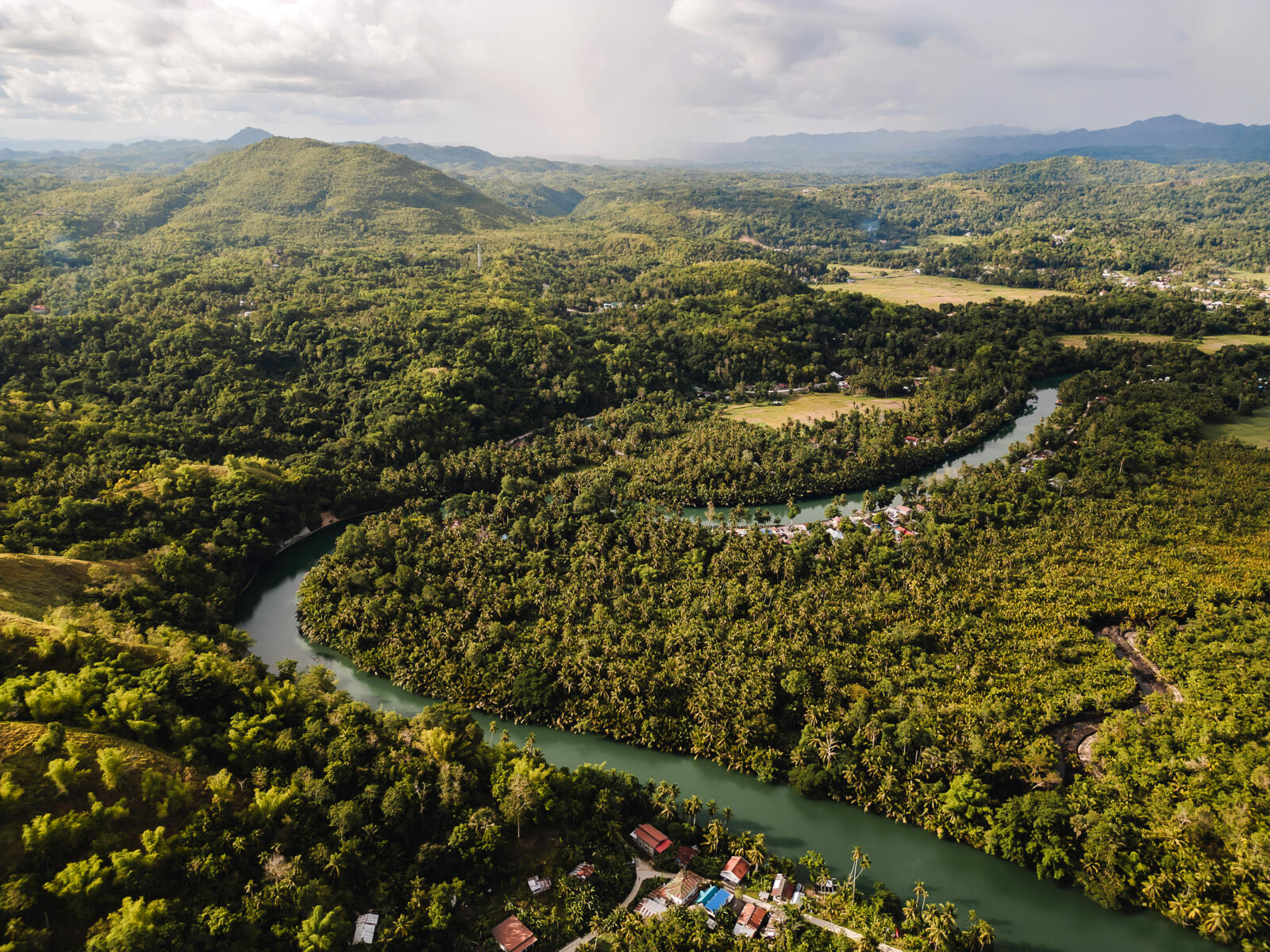 Luchtfoto van de kronkelende Loboc-rivier omringd door dichte jungle en groene heuvels op het eiland Bohol in de Filipijnen.