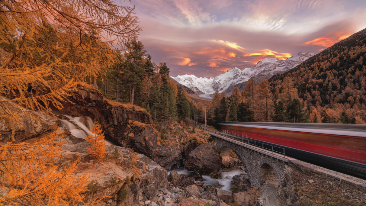 De Bernina Express rijdt langs de kleurrijke herfstbossen, Morteratsch, Engadin, kanton Graubünden, Zwitserland