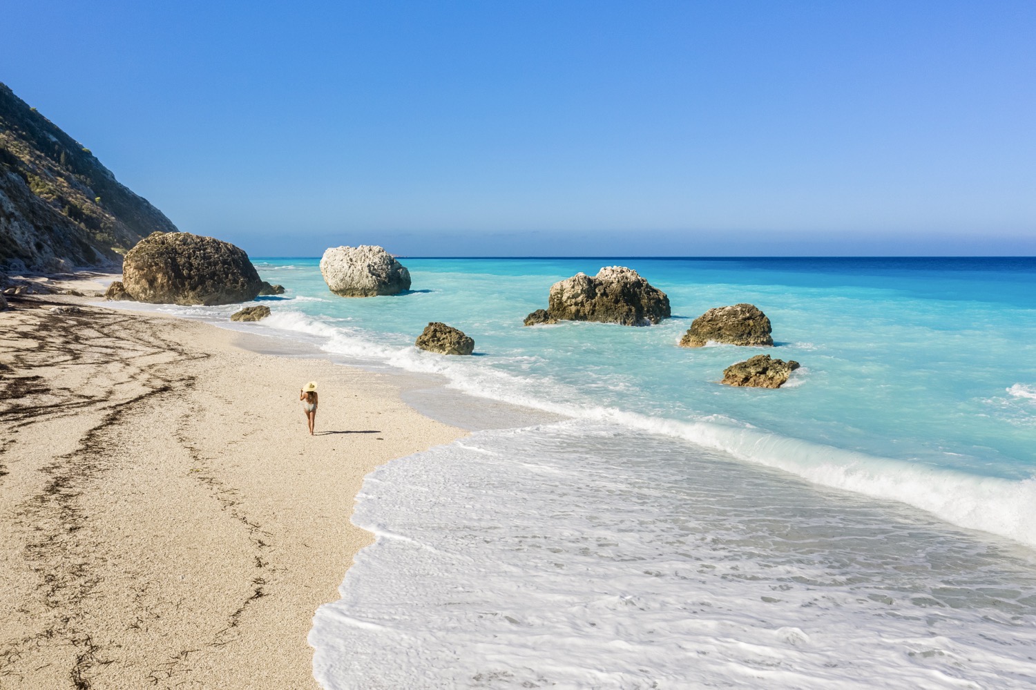 Je hoeft niet altijd twaalf uur in een vliegtuig te zitten voor water dat licht lijkt te geven. De Ionische eilanden Lefkas en Cefalonia staan bekend om hun indrukwekkende steilkusten van krijtrotsen die uitmonden in stranden als Porto Katsiki en Myrtos Beach. Het water is er zo intens blauw dat je je afvraagt of er een filter over de werkelijkheid ligt.