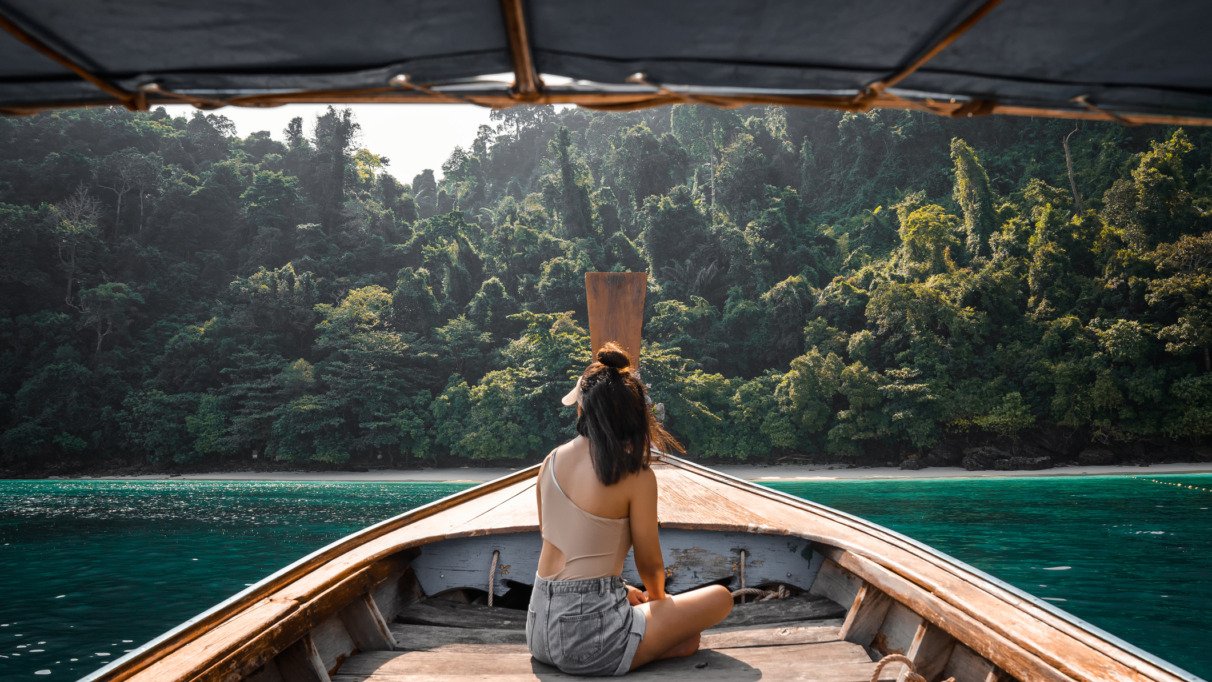 Jonge vrouwelijke toerist op een longtailboot bij het eiland Koh Phi Phi, Phuket, Thailand.