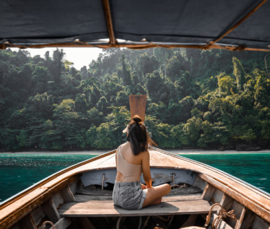Jonge vrouwelijke toerist op een longtailboot bij het eiland Koh Phi Phi, Phuket, Thailand.