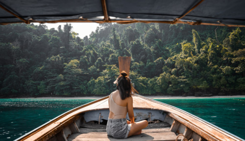 Jonge vrouwelijke toerist op een longtailboot bij het eiland Koh Phi Phi, Phuket, Thailand.