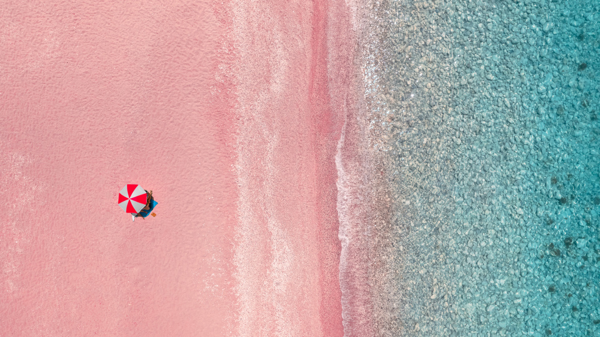 Luchtfoto van parasol op een roze strand
