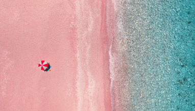 Luchtfoto van parasol op een roze strand