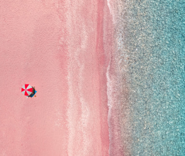 Luchtfoto van parasol op een roze strand