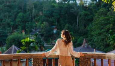Vrouw op het balkon van een resort tijdens haar reis naar de jungle in Bukit Lawang, Sumatra, Indonesië
