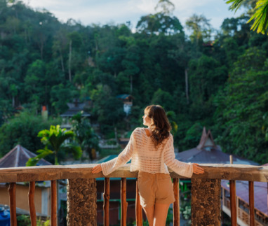 Vrouw op het balkon van een resort tijdens haar reis naar de jungle in Bukit Lawang, Sumatra, Indonesië