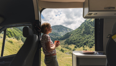 Een volwassen vrouw geniet vanuit haar camper van het uitzicht op de vallei in de Franse Pyreneeën