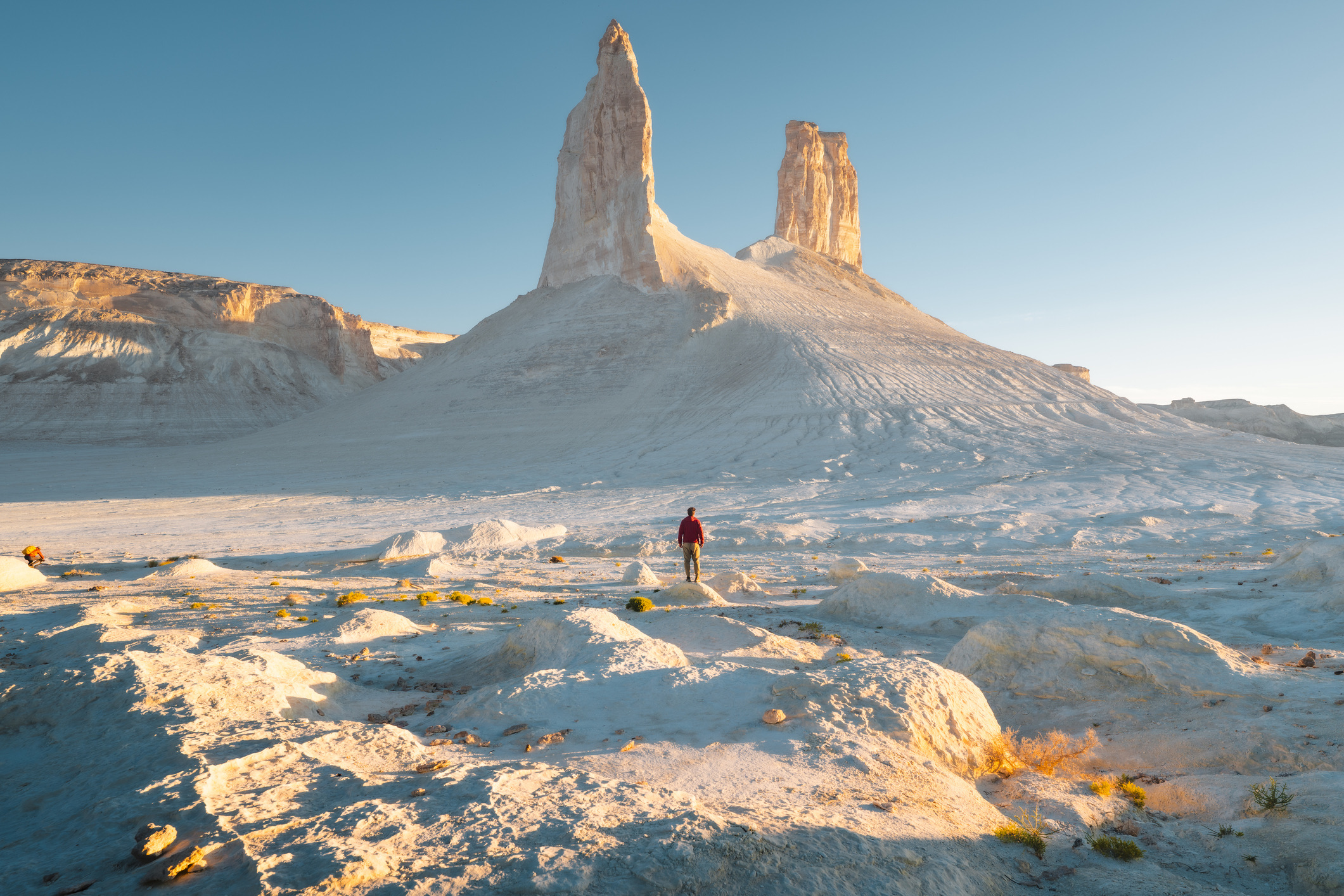 Verborgen in het westen van Kazachstan ligt een van 's werelds meest buitenaardse en ongerepte landschappen. Duizenden jaren geleden maakte de regio Mangystau in Kazachstan deel uit van de prehistorische Paratethys-zee. Tegenwoordig wandel je in het ravijn van Bozzhyra over opgedroogde zoutwoestijnen en kleivlaktes, waar spierwitte kalksteenkliffen en bizarre rotsnaalden uit oprijzen. Op het uitgestrekte plateau zie je hoe de witte zoutkorst zich uitstrekt tot aan de horizon, afgewisseld met roze zoutlagunes.