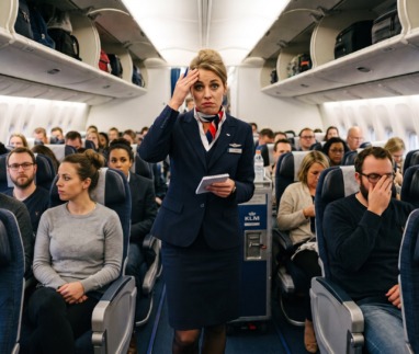 Stewardess staat wanhopig in gangpad vliegtuig