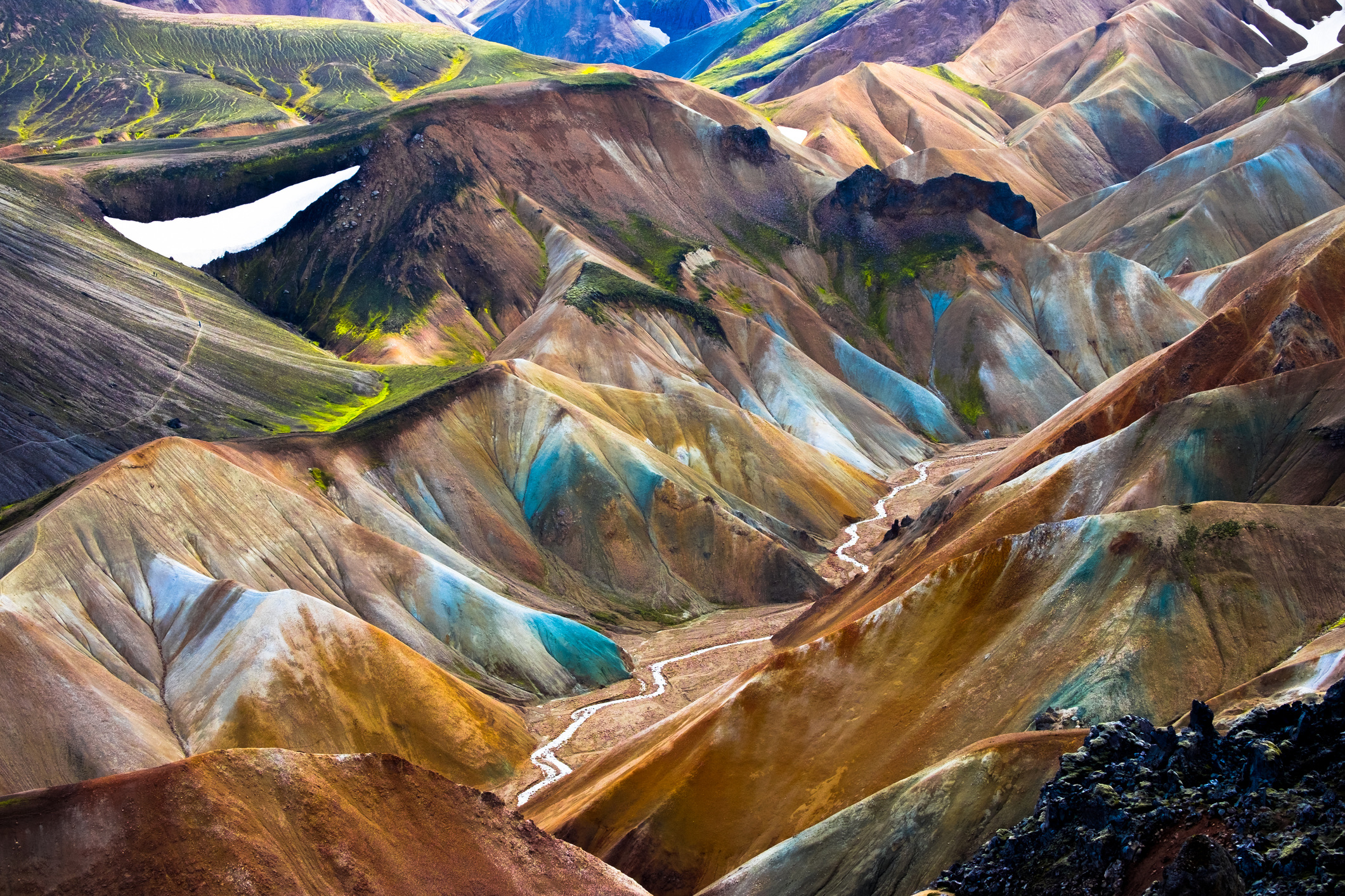 In het ruige binnenland van IJsland ligt de vulkanische regio Landmannalaugar. Het landschap bestaat grotendeels uit rhyoliet, een zuur vulkanisch gesteente dat langzaam afkoelde. Het resultaat is een betoverend palet van pastelgeel, oker, rood, blauwgroen en diepzwart gecombineerd met stoom die opstijgt uit omringende geothermische bronnen.
