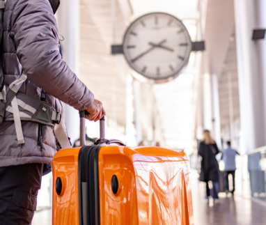 toerist die naar het vertrek- en aankomstbord op de internationale luchthaven kijkt