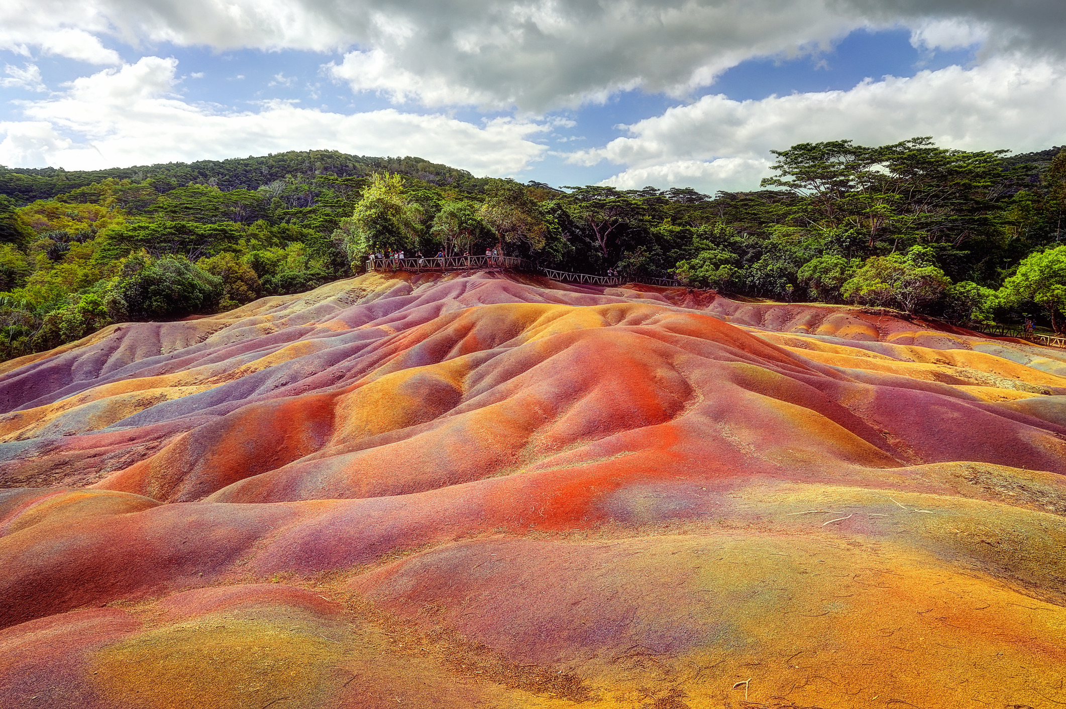 Midden in de tropische jungle van Mauritius vind je een uniek geologisch fenomeen: een kleinschalig duinlandschap bestaande uit zeven afzonderlijke kleuren zand (rood, bruin, violet, groen, blauw, paars en geel). De basaltische lava transformeerde door verwering in kleimineralen, waarbij ijzer en aluminium zich scheidden in strakke kleurgradaties die zelfs na hevige regenval niet door elkaar mengen.
