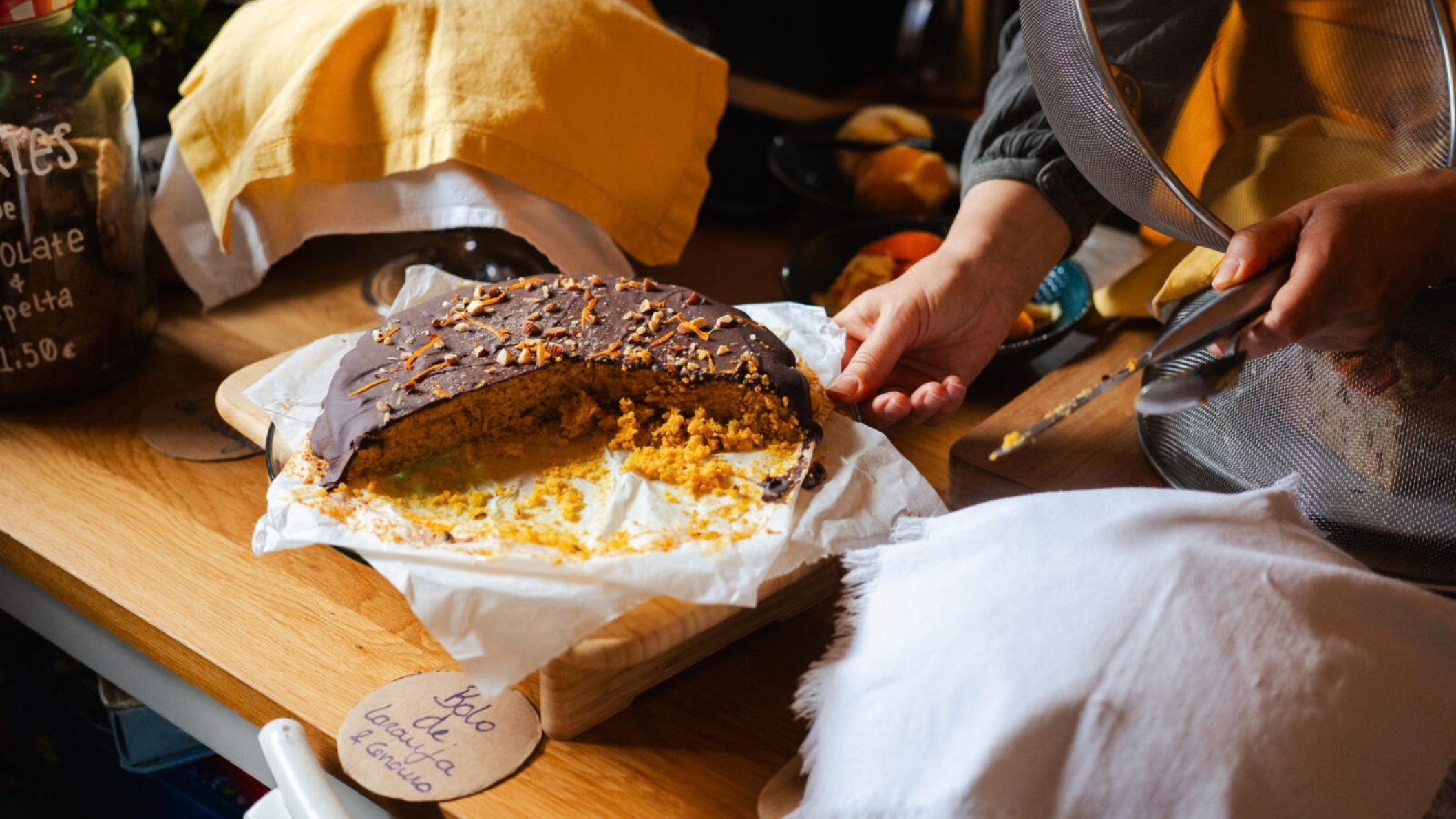 Zelfgemaakte taart met chocoladelaag op een houten plank bij vegetarisch restaurant In Natura in Campo