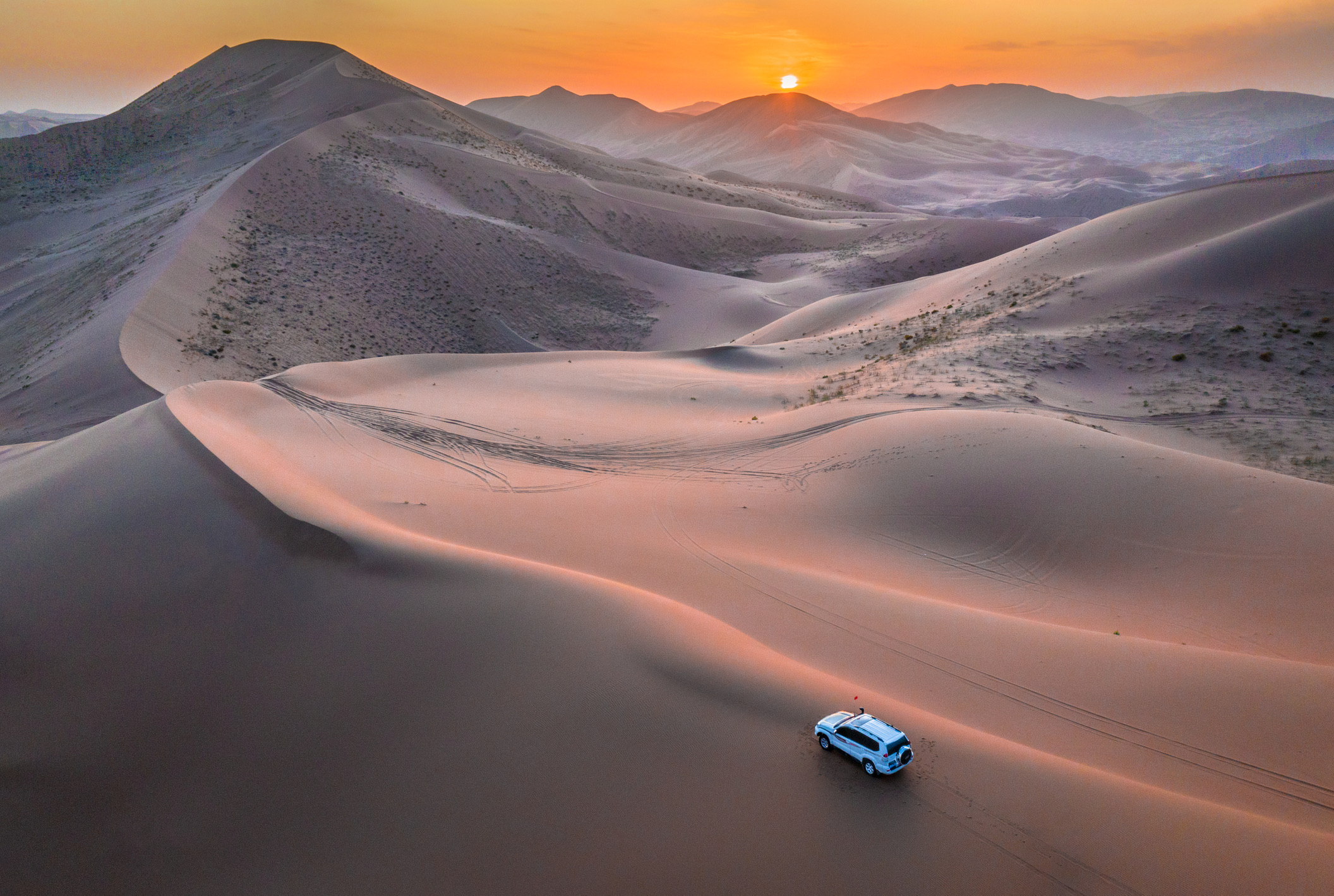 Zonsondergang boven de eindeloze zandduinen in de Badain Jaran-woestijn, gelegen in de Autonome Regio Binnen-Mongolië in China.