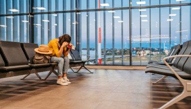 Een vermoeide vrouw die op de luchthaven wacht op haar vertraagde vlucht