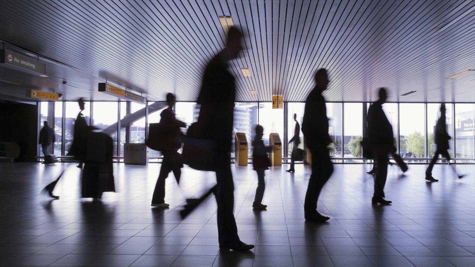 Silhouet van een groep reizigers op de luchthaven Schiphol in Amsterdam, Nederland.