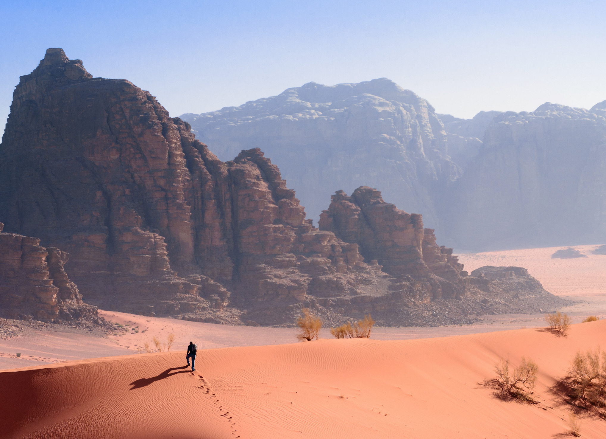 Een wandelaar op een bergkam in de woestijn van Wadi Rum, Jordanië