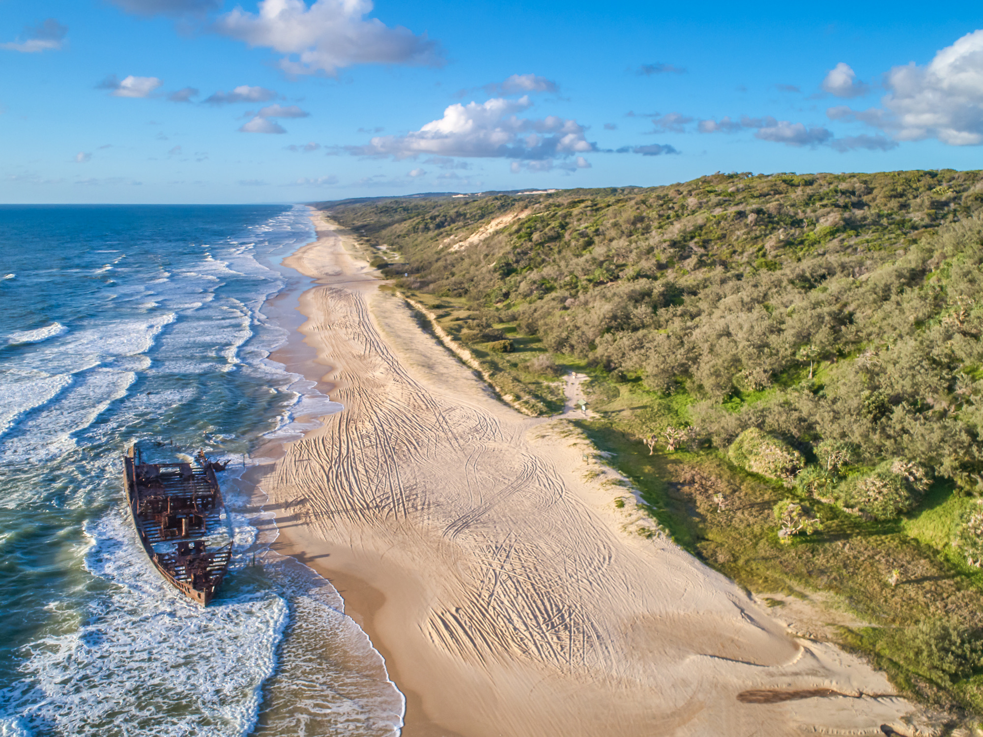 Luchtfoto van het scheepswrak ‘Maheno’, een bekend herkenningspunt op Fraser Island. Het was een voormalig Trans-Tasman-passagiersschip dat in 1935 tijdens een cycloon op het strand werd geslingerd, Fraser Island, Queensland, Australië