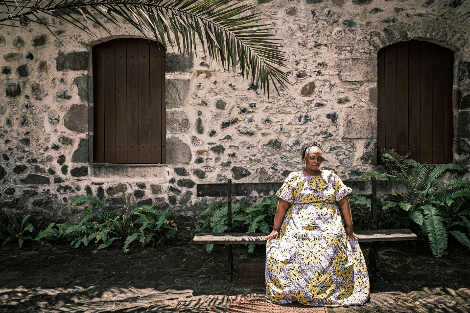 Audrey Adelaide, werkzaam in rummuseum en voormalig suikerrietplantage Habitation La Salle, poseert voor een foto. Tijdens de hoogtijdagen van de suikerproductie, in de achttiende eeuw, stonden er honderden suikerfabrieken op het eiland. Toen Europa aan het einde van die eeuw zelf suiker begon te produceren, moesten de Martinikanen een manier vinden om andere producten van suikerriet te maken. Rum is het resultaat.