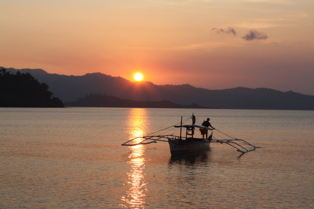 Typische filipijnse vissersboot in de ondergaande zon