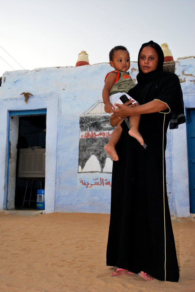 Moeder met arm op de kind in een Nubisch dorp