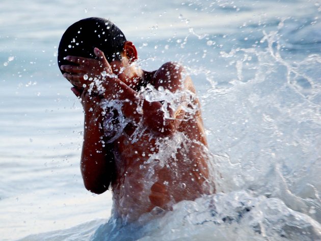 jongetje spelend in de zee bij Playa del Carmen