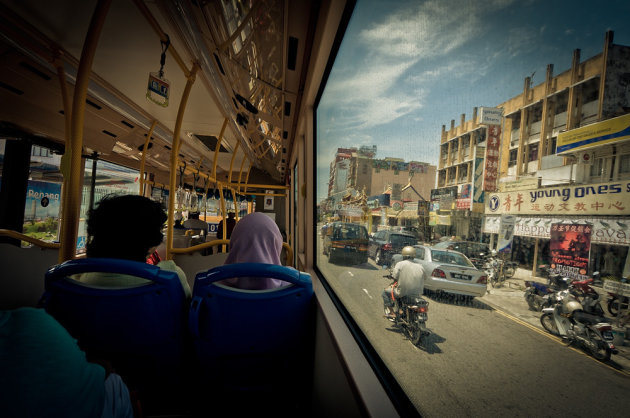 2 mensen zitten in de bus en rijden door Georgetown op Penang