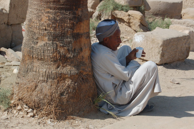 Hangpalm? Portret van rustende Egyptenaar bij tempel