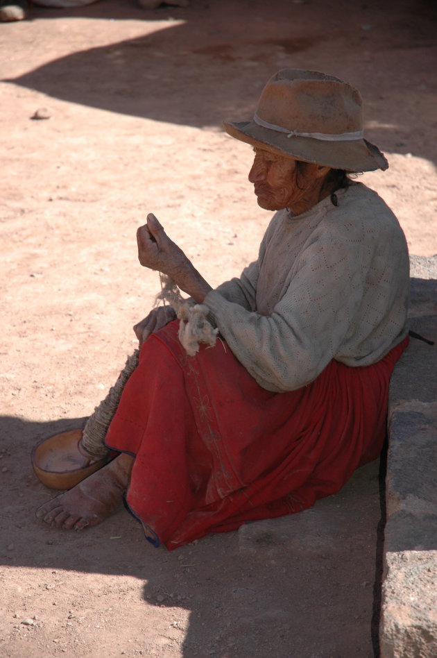 Oude vrouw met een klos met wol