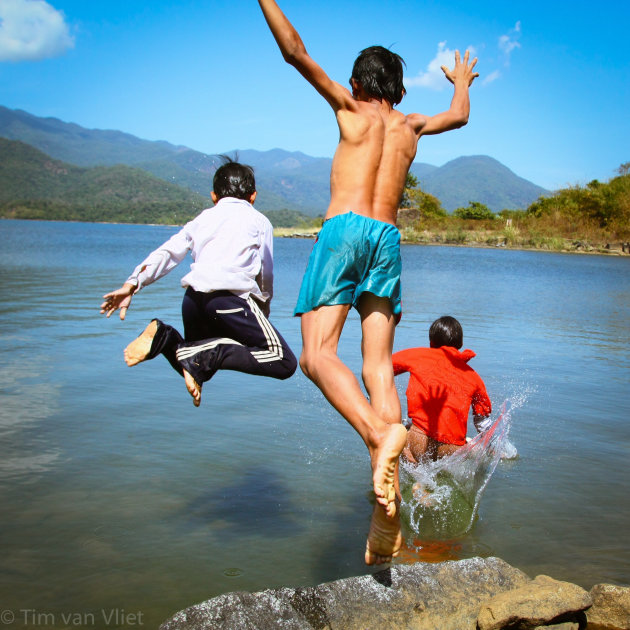 3 jongens springen in het water.