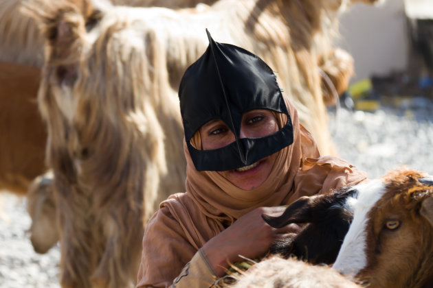 Omaanse vrouw met vogelbekmasker op geitenmarkt
