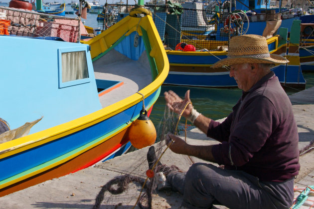 A Fisherman mending his fishnet at Marsaxlokk