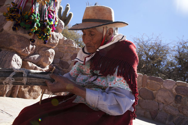 Oude dame (81) uit Humahuaca breidt in de brandende zon een straat
