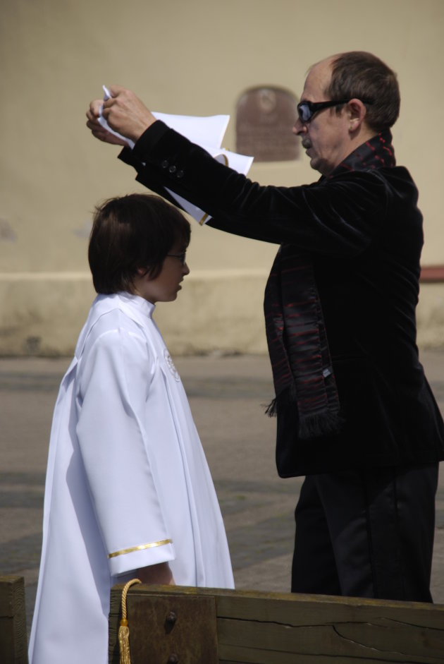 Vader helpt zijn zoon in zijn communie-jurk