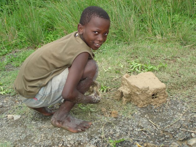 Xhosa jongetje bouwt huis van klei