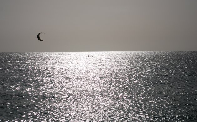 Een kitesurfer tijdens de zonsondergang