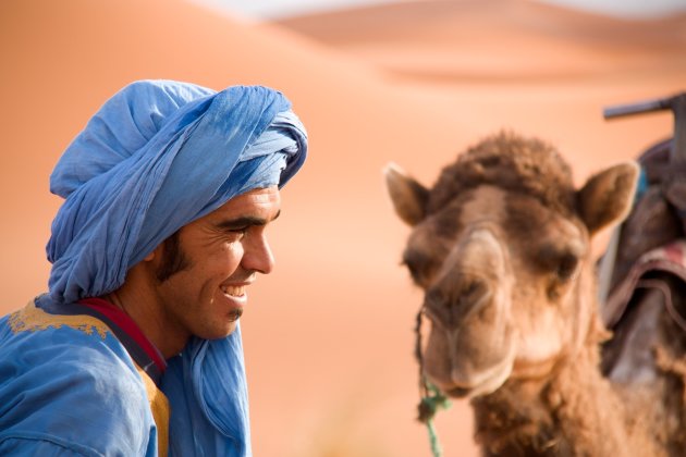 Touareg met zijn kameel in de woestijn van Marokko