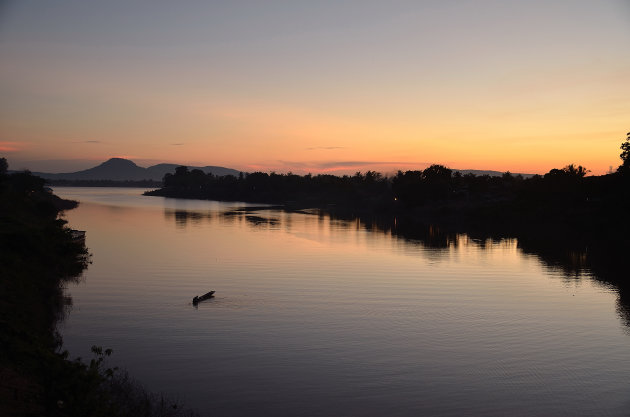 Visser bij zonsondergang bij Paksé, Laos