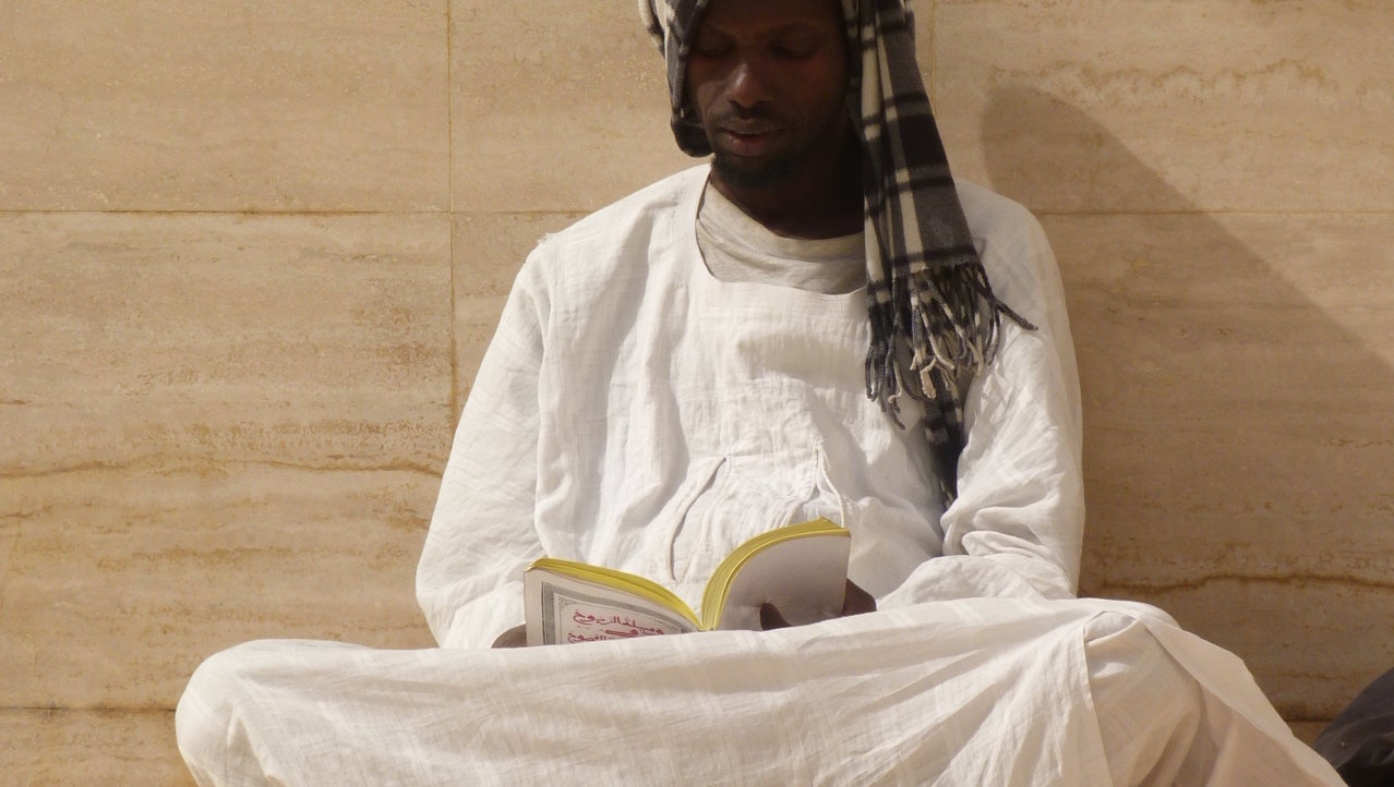 Biddende man in moskee van Touba