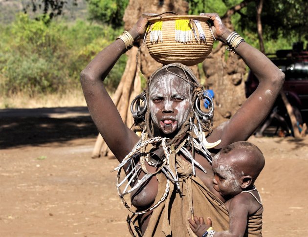 Kind aan de borst bij moeder Mursi stam Zuid-Ethiopie