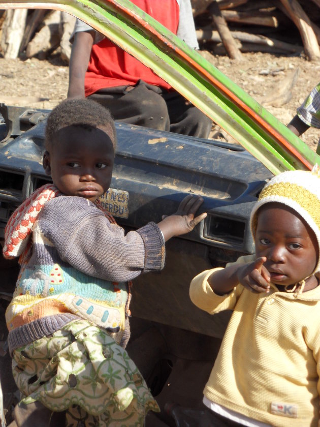 Kinderen spelen in een volledig gestripte taxi in een buitenwijk van Ouagadougou