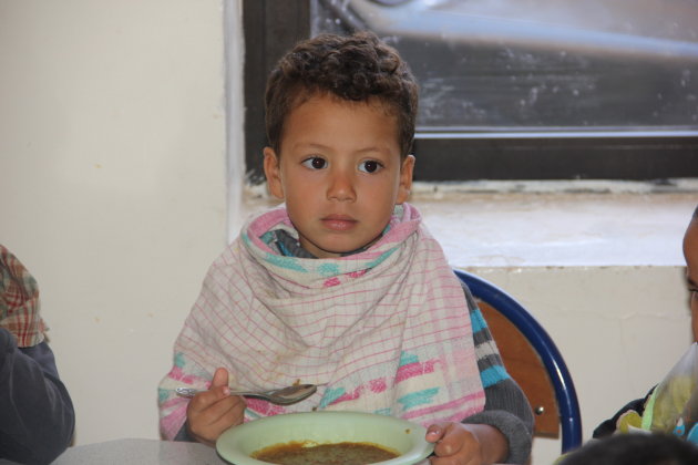 Jongetje in een weeshuis aan het eten. 