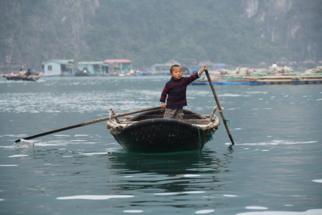 Jongetje in een bootje in Ha Long Bay
