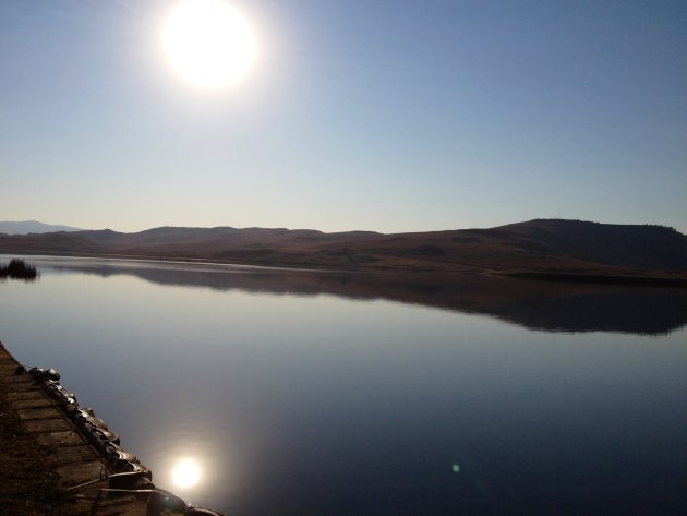 Reflectie van de zon in het meer bij Drakensbergen