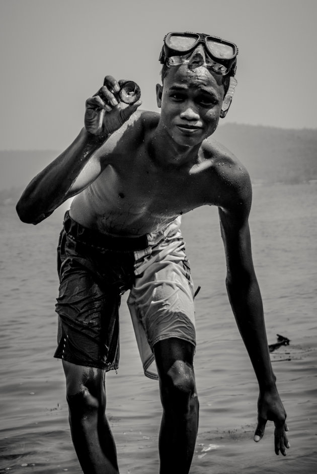Cambodjaanse jongen duikt schelp op